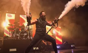 Skillet na koncercie w Warszawie, wokalista John Cooper strzela dymem z ręki.