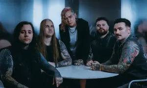 Zespół Lorna Shore Polska przy okrągłym stole, z tatuażami i w mrocznym klimacie.
