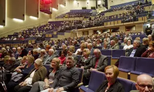 Widownia filharmonii, ludzie siedzą w rzędach. Eleganckie stroje, jak się ubrać do filharmonii.